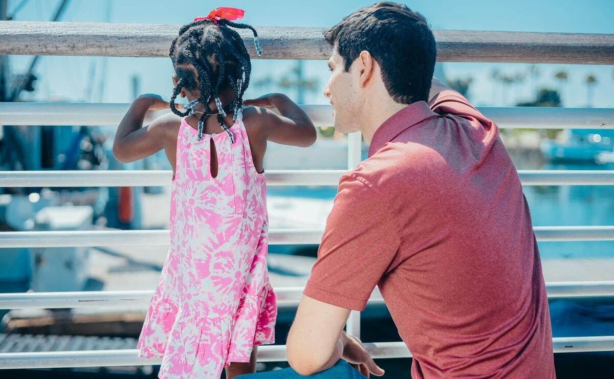 Man and young girl enjoying quality time together on a sunny day by the water.