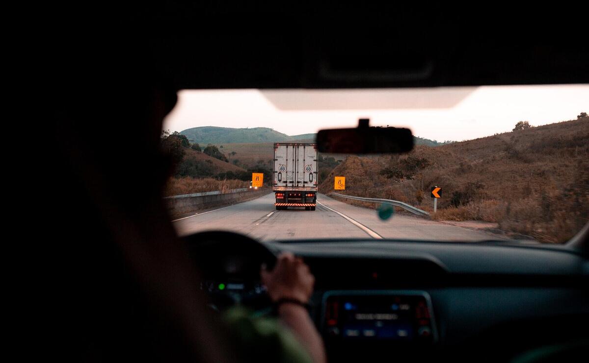 Scenic drive with a truck on a highway surrounded by hills. Perfect for travel themes.