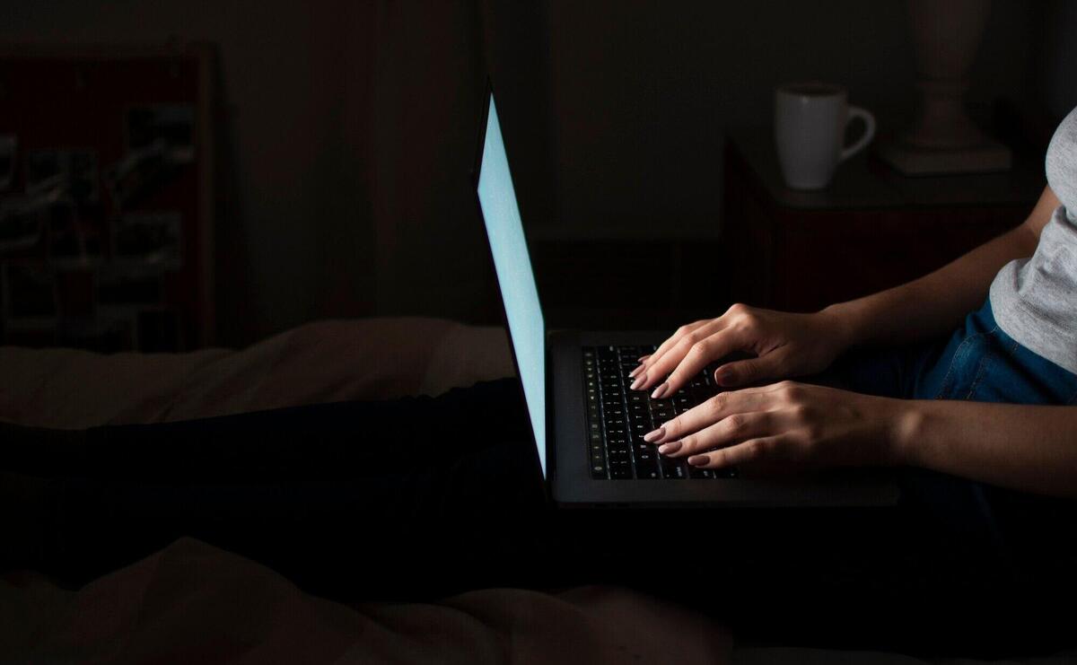 Side view of woman working late at home on laptop