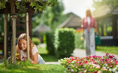 Female teen and her mother taking care of backyard plants