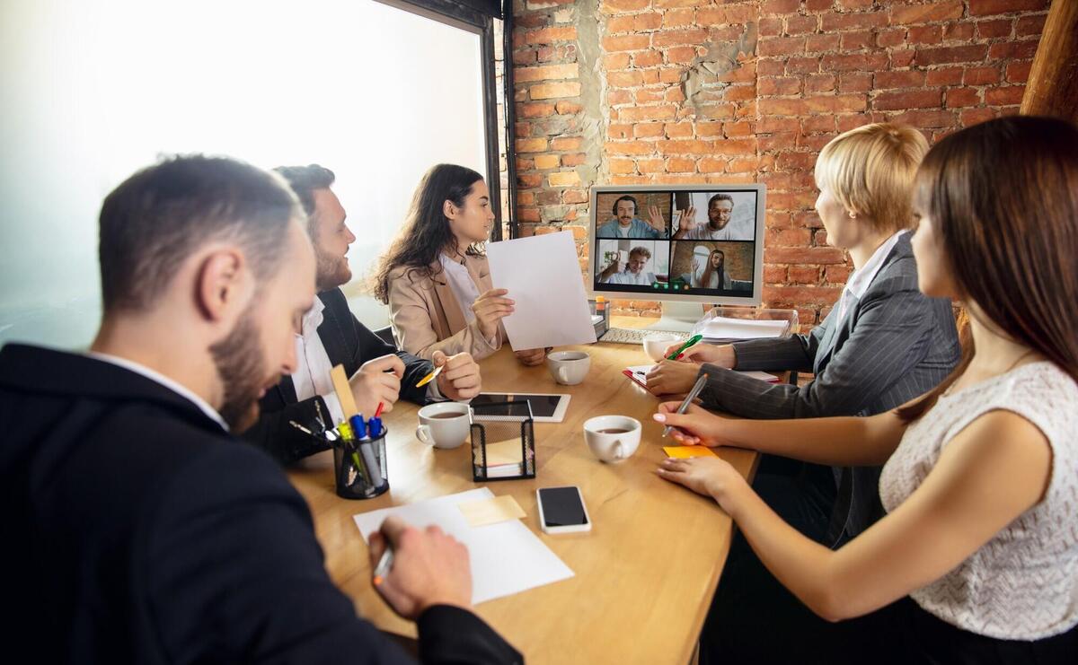 People talking, working during videoconference with colleagues at office.