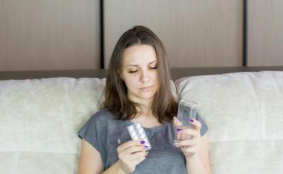 a woman sitting on a couch looking at her cell phone