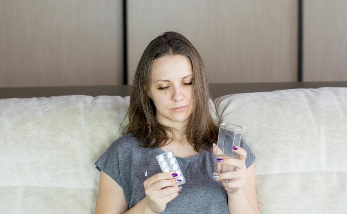 a woman sitting on a couch looking at her cell phone