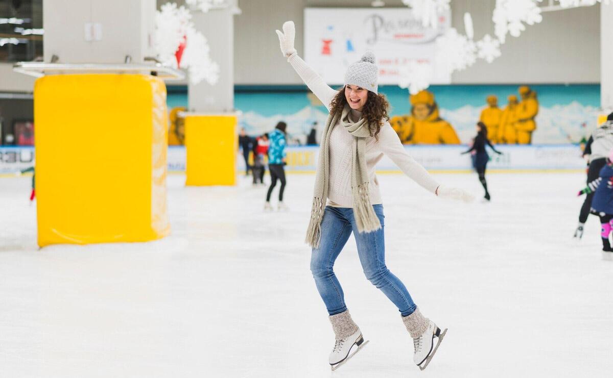 Cheerful woman skating on rink