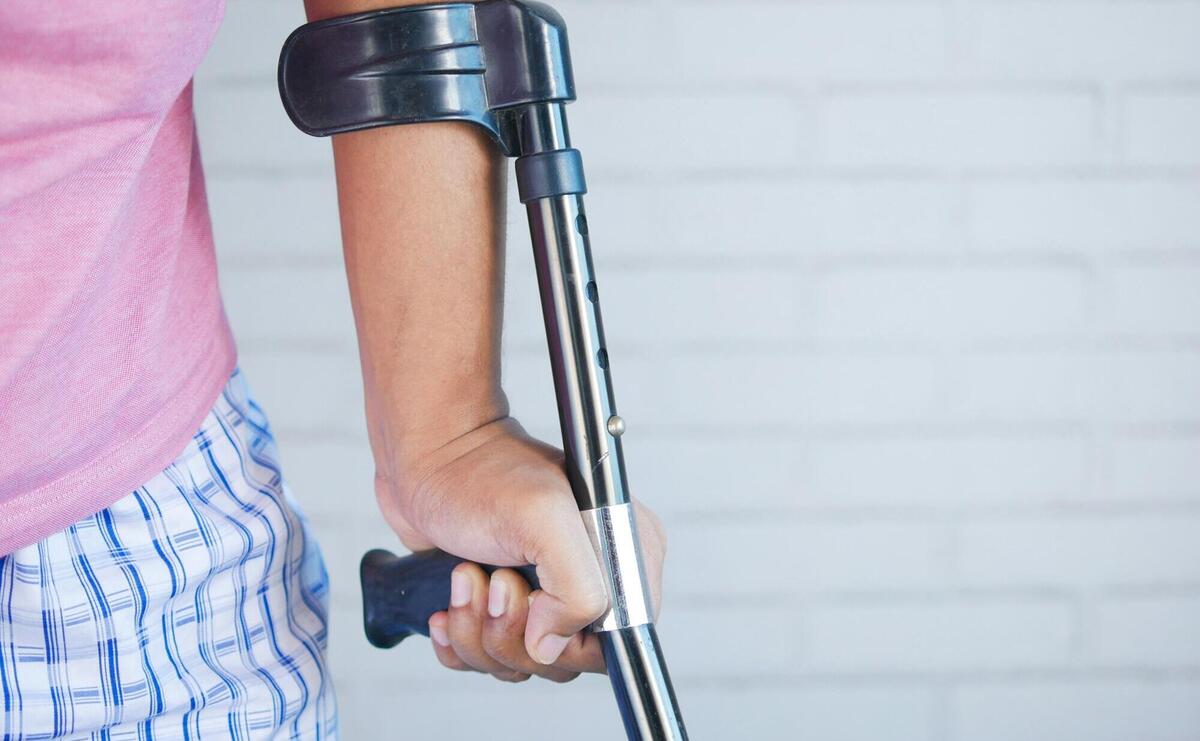 a person holding a crutch and walking cane