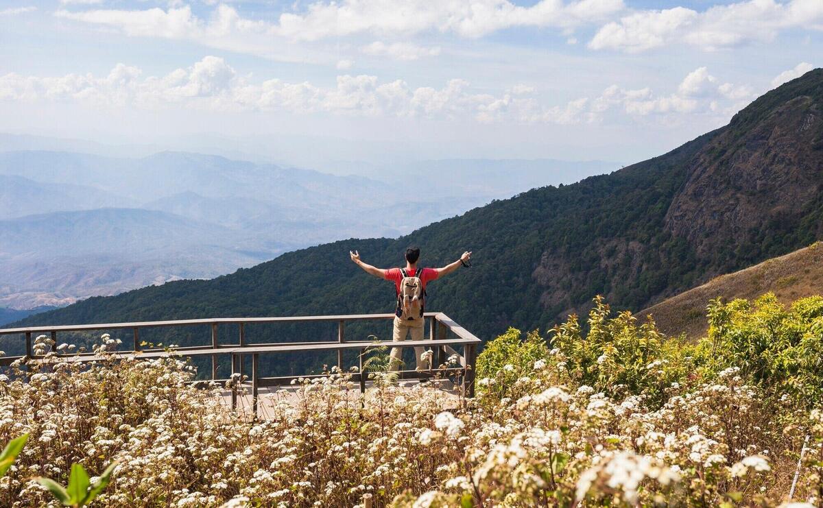 Hiker raising arms on viewing platform