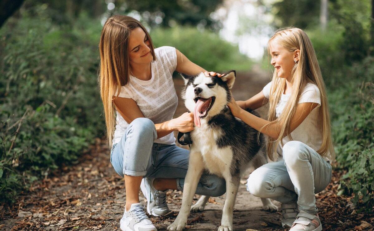 Two sisters with their dog in park