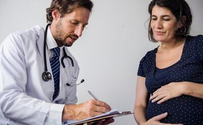 Pregnant woman having fetal monitoring by doctor