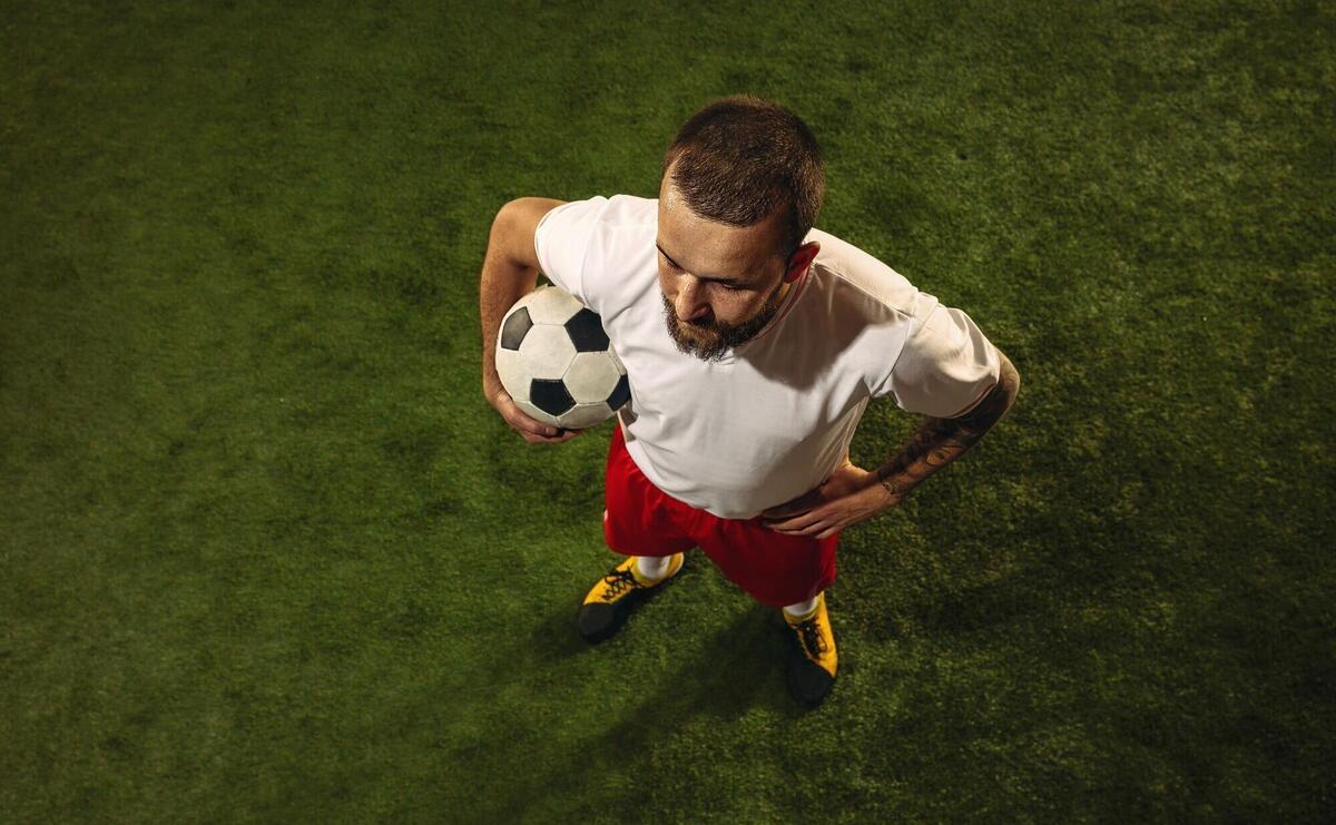 Top view of football or soccer player on green grass