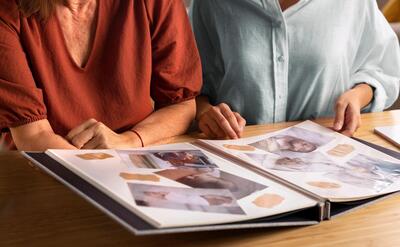 People looking at picture album front view