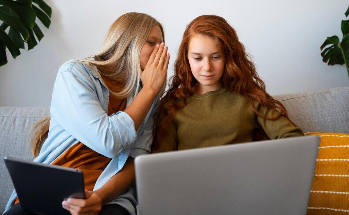 Front view girl whispering in friend's ear