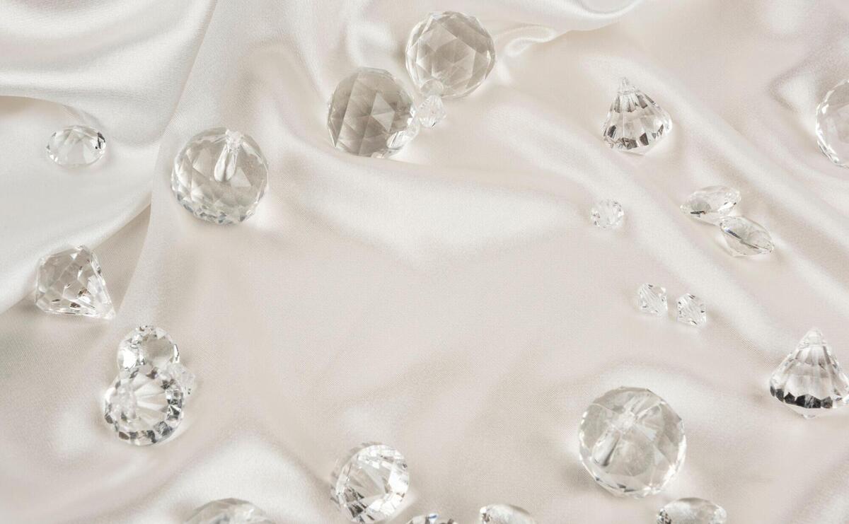 Decorative clear diamonds on white fabric textured background