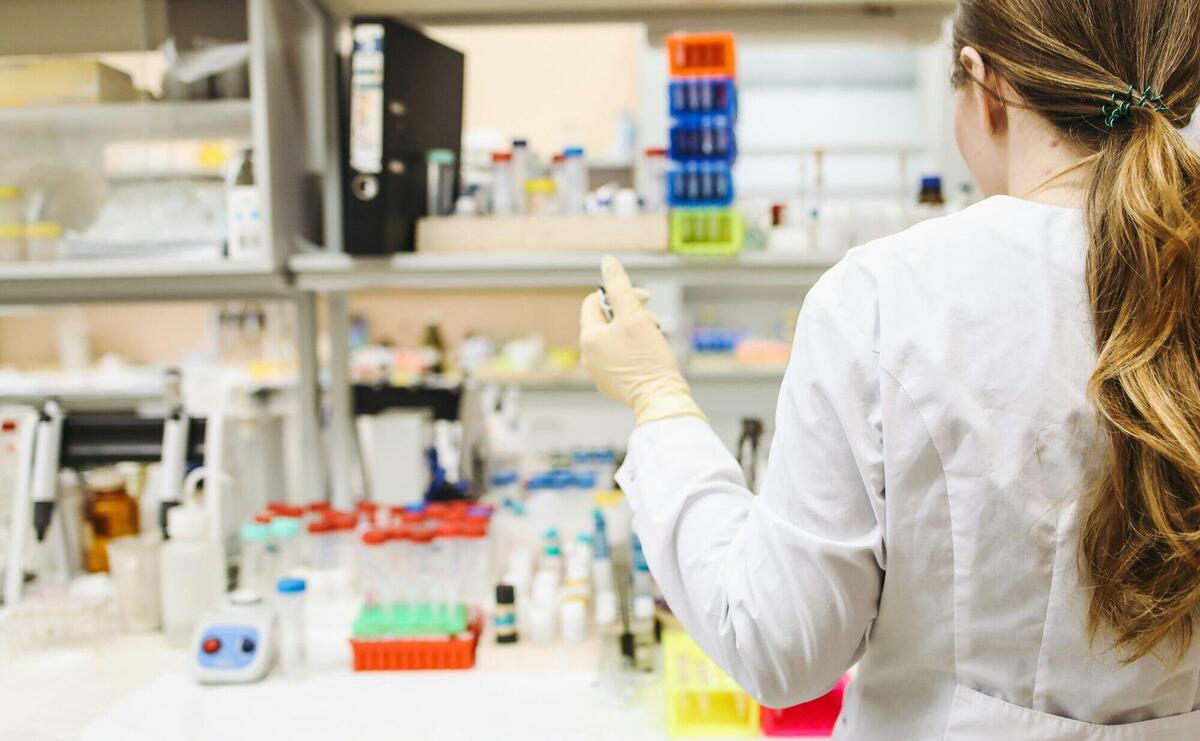 A woman in a laboratory setting conducting scientific research with test tubes.