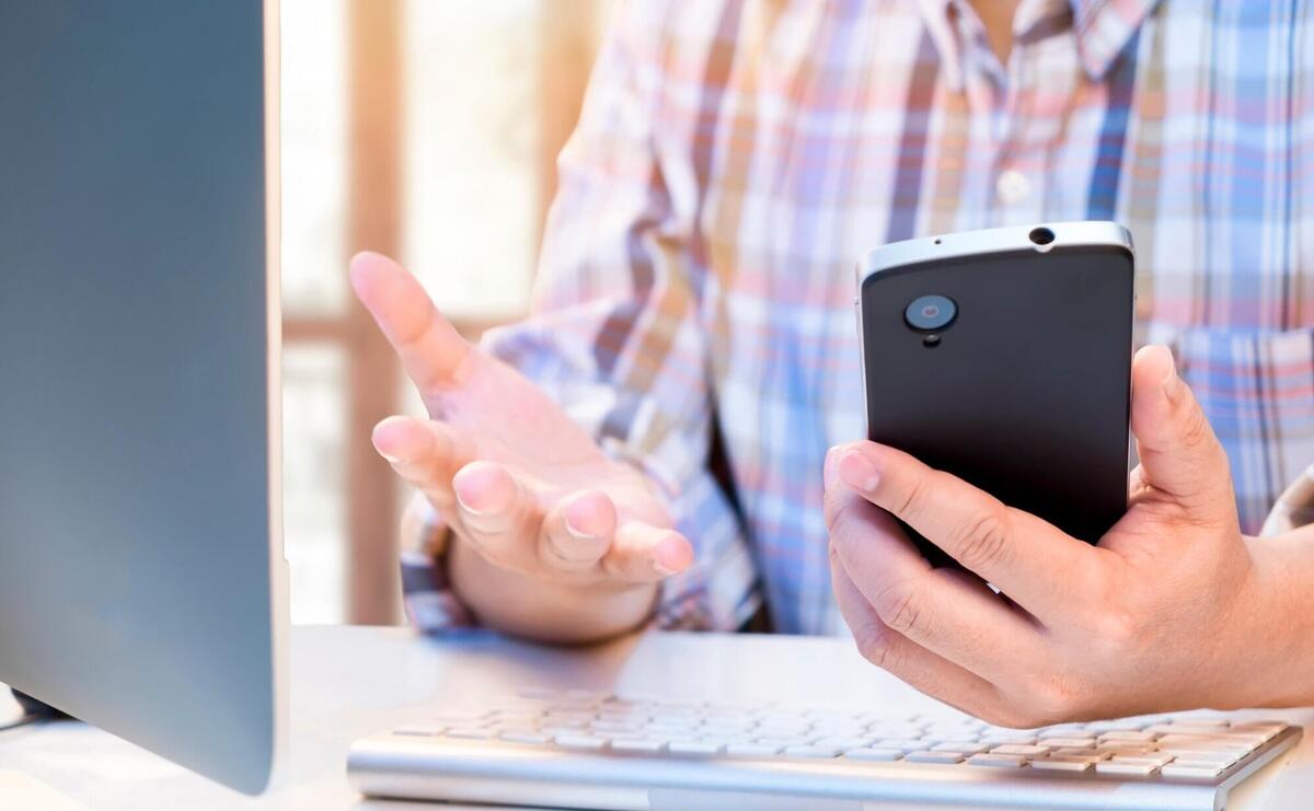 Businessman using smartphone and computer to analize information