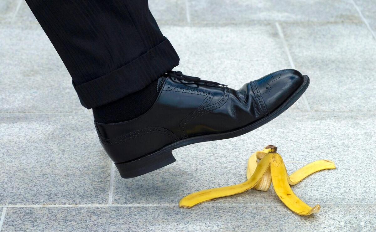 A person is going to step on a banana peel