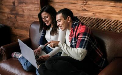 Adorable couple together with a laptop