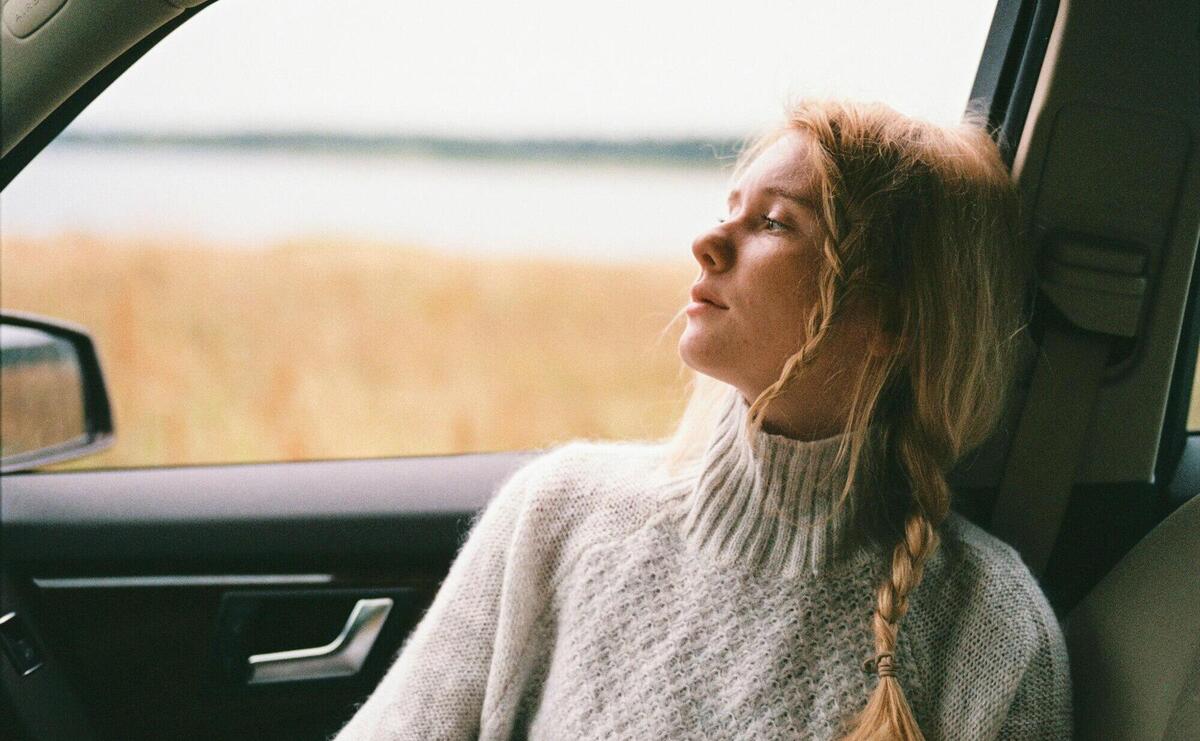 Woman in Sweater Sitting Inside a Car