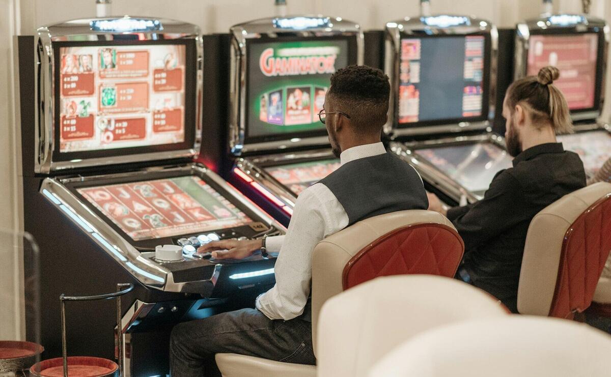 Men Sitting in Front of a Slot Machine