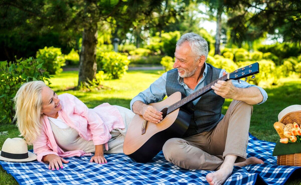 Old man playing guitar for his woman