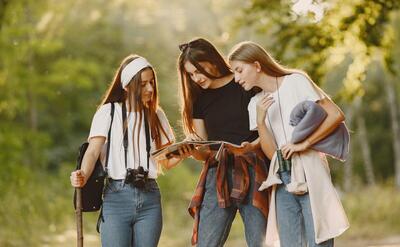 Adventure, travel, tourism, hike and people concept. Three girls in a forest.