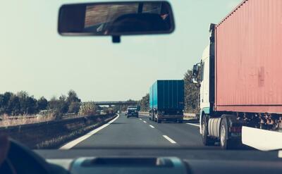 View through rearview mirror of trucks on a German highway, driving towards Bamberg.