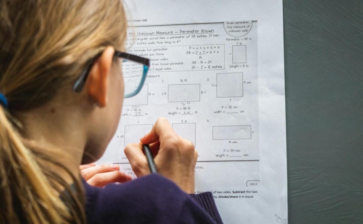 woman in black framed eyeglasses holding pen