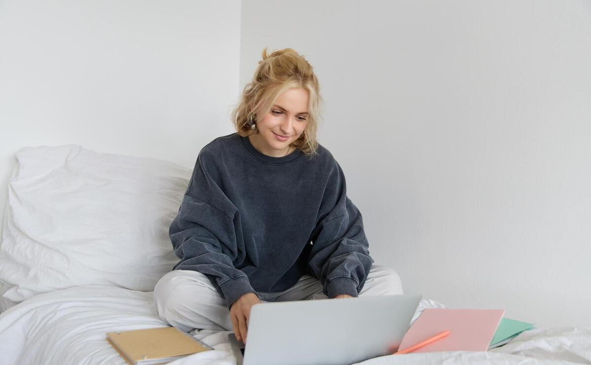 Image of happy young woman student elearning from home connect to online course on her laptop sits