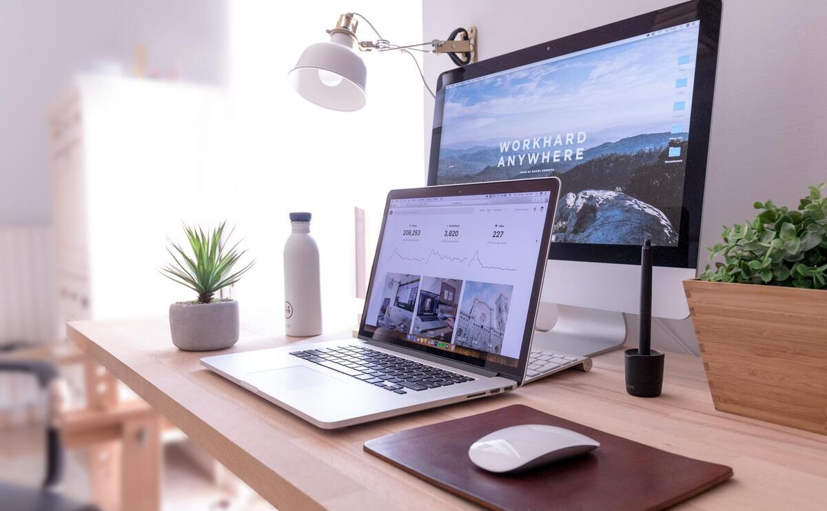 MacBook Pro on table beside white iMac and Magic Mouse