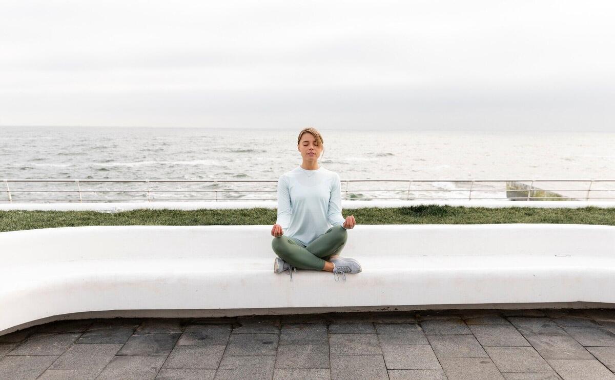 Long shot woman meditating outdoors