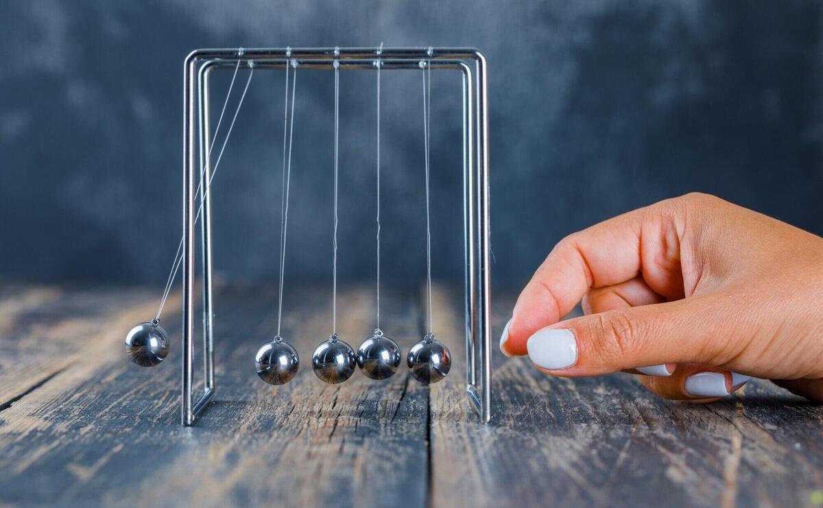 Woman working on newton's cradle.