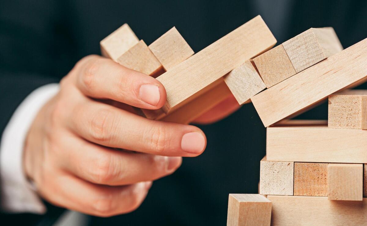 Man and wooden cubes on table. Management concept