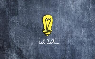Yellow idea light bulb on chalkboard