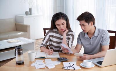Man and woman calculating domestic budget at home