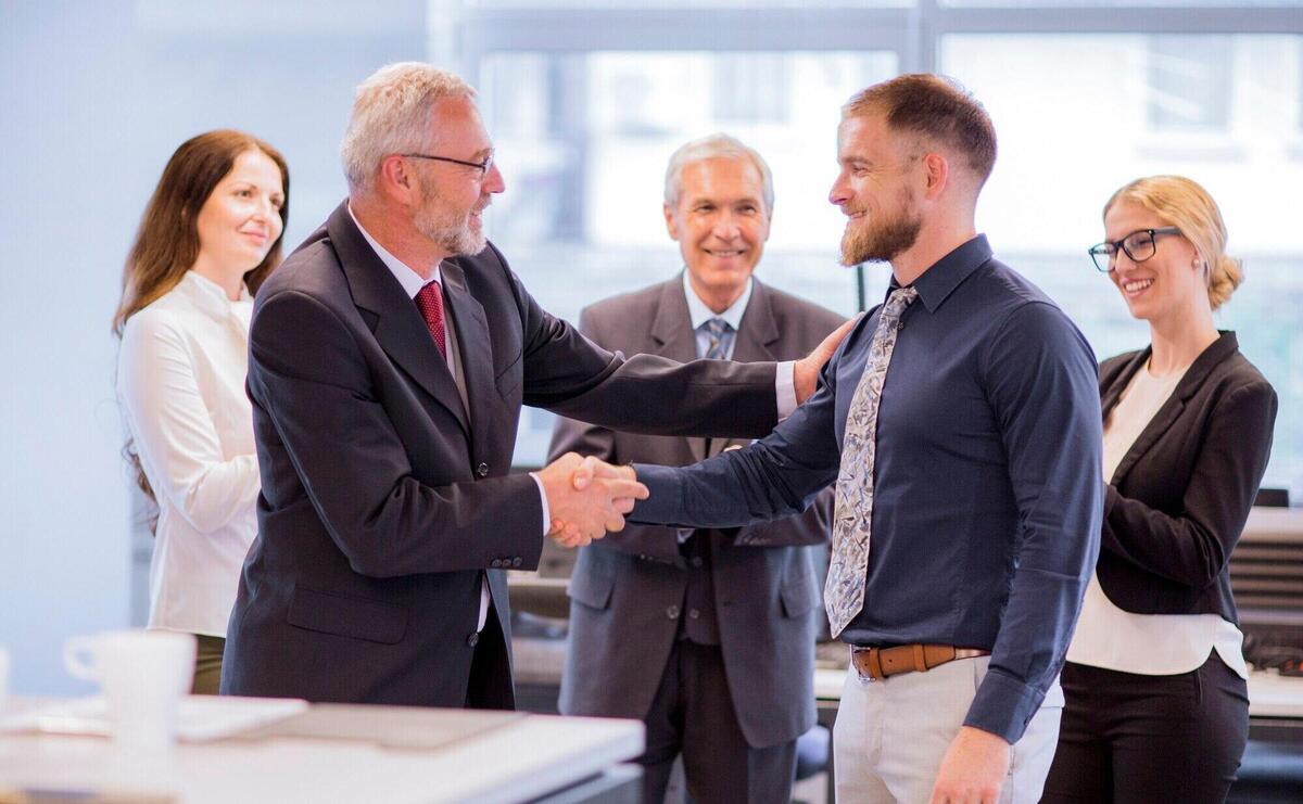 Two businessmen shaking hands congratulating on promotion