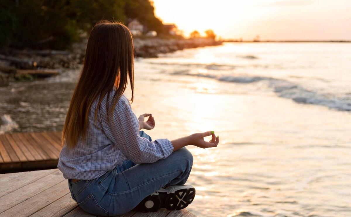 Side view woman looking at the sea at sunset with copy space