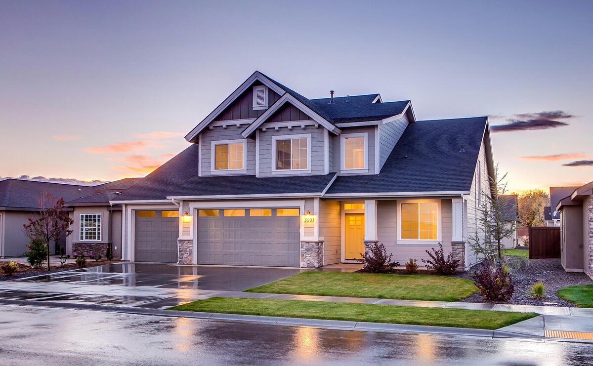 Elegant suburban home with driveway at sunset showcasing modern architecture.