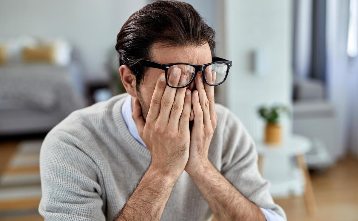 Young businessman feeling exhausted while working at home