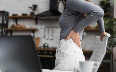 Side view woman having a backache while working from home