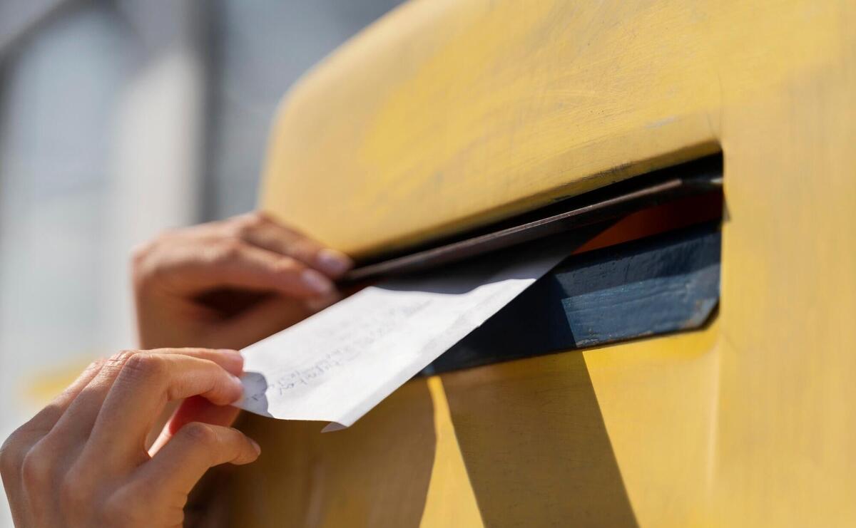 Close up woman at mailbox with envelope