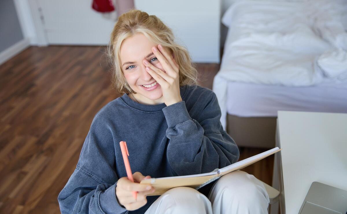 Portrait of smiling charismatic young woman writing down notes making plans and putting it in