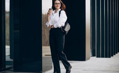 Young business woman drinking coffee by the business center