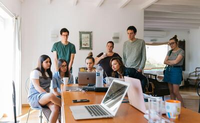 Group of young professionals engaged in a collaborative meeting in a modern office setting.