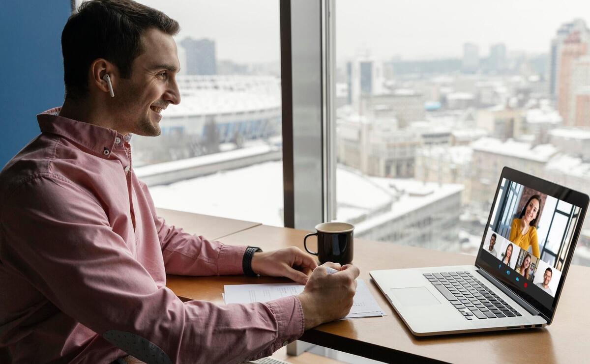 Side view of man having an online video call with coworkers