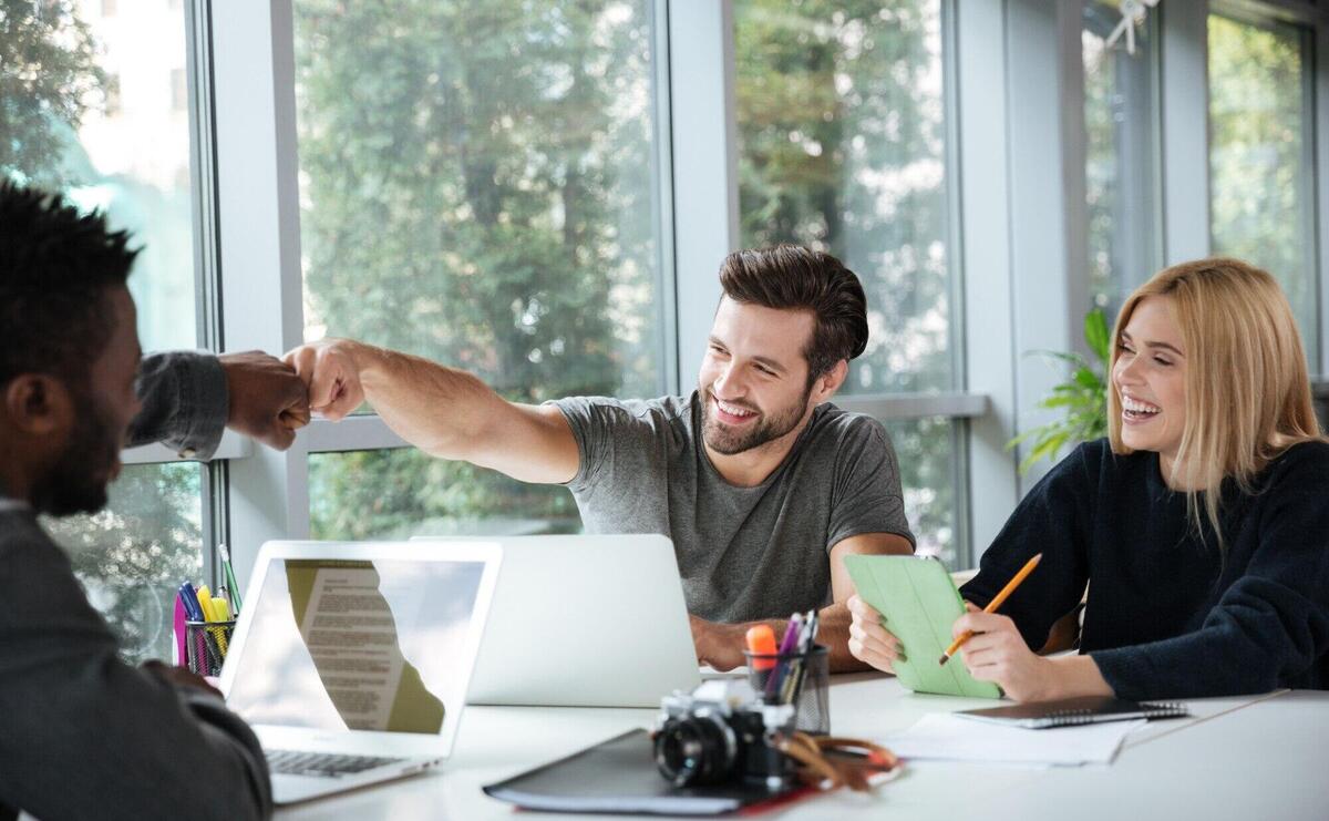 Smiling young colleagues sitting in office coworking