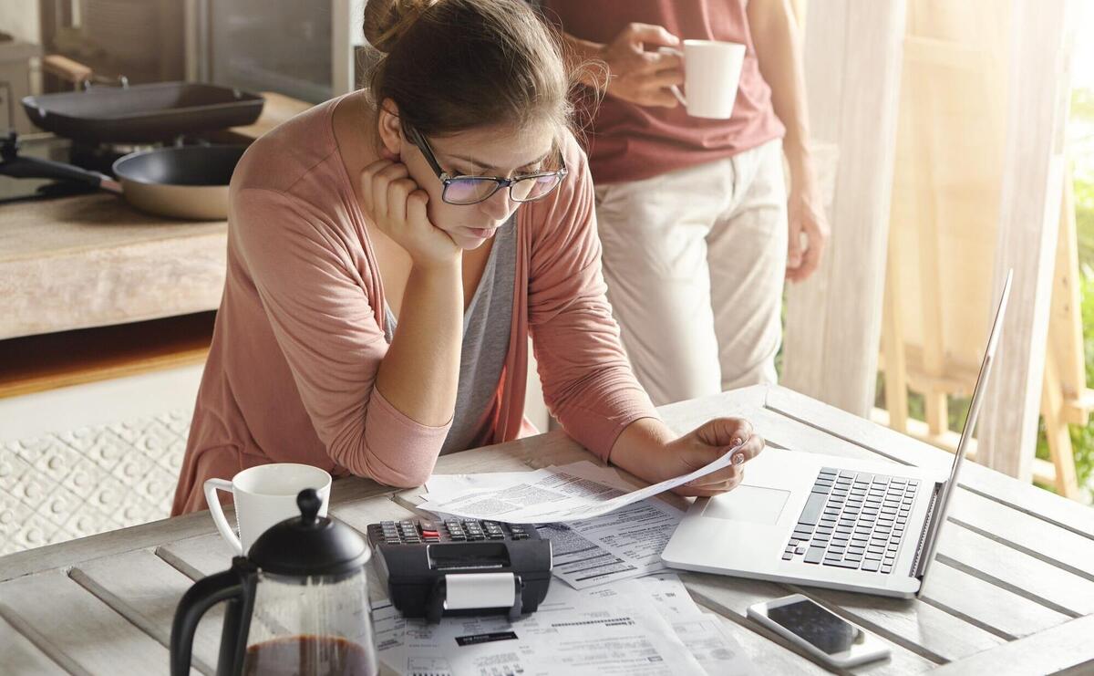 Young housewife dressed casually focused on paperwork