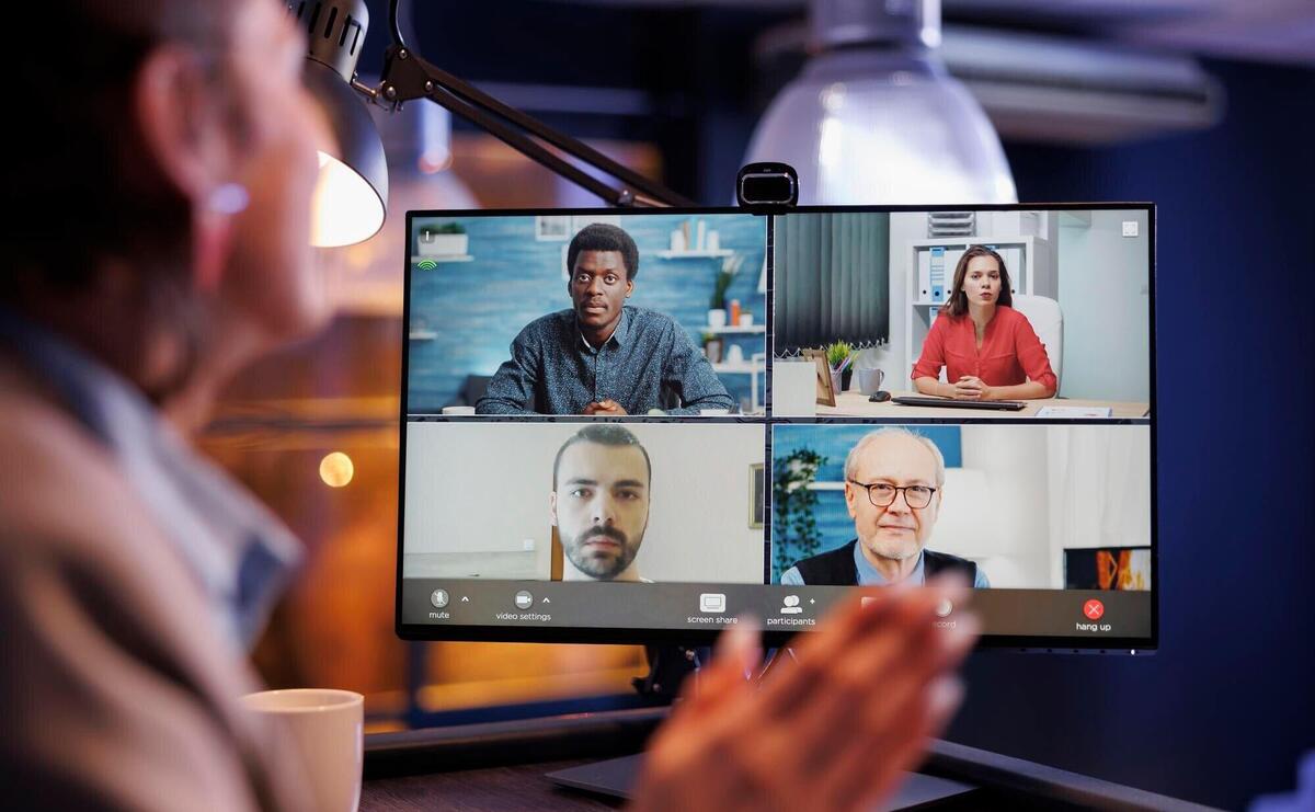 Manager greeting remote colleagues during videocall meeting conference planning company startegy Business coworkers working late at night at company investment plan to help increase profit