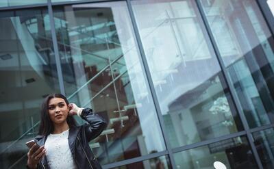 Thoughtful woman holding mobile phone