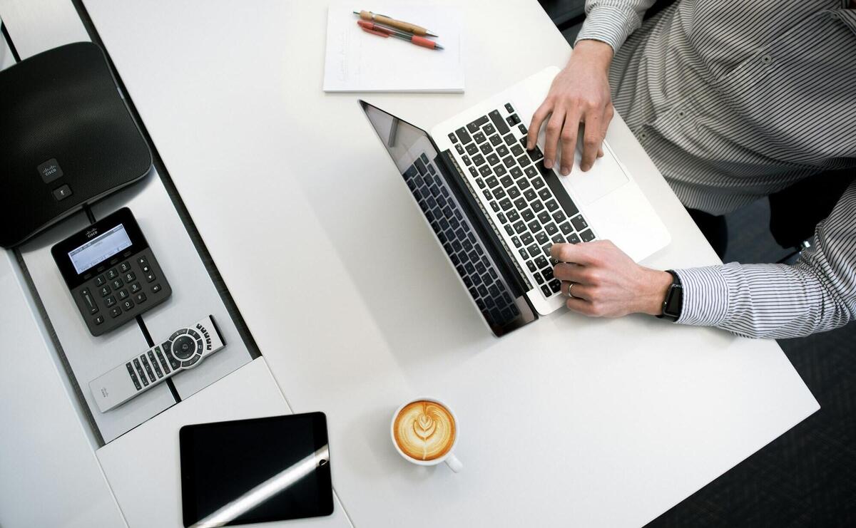 person using laptop on white wooden table