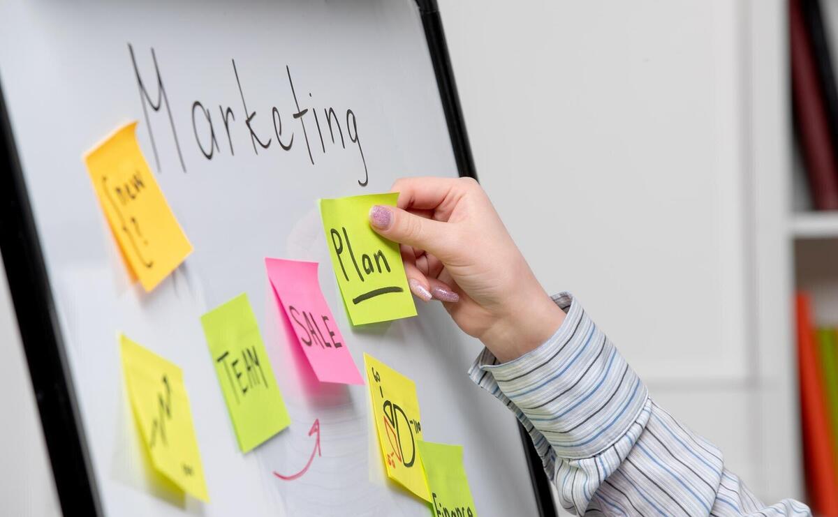 Marketing young cute business lady in striped shirt in office creating new marketing plan