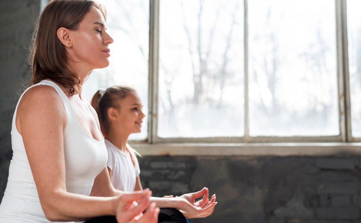 Low angle mother and daughter meditating